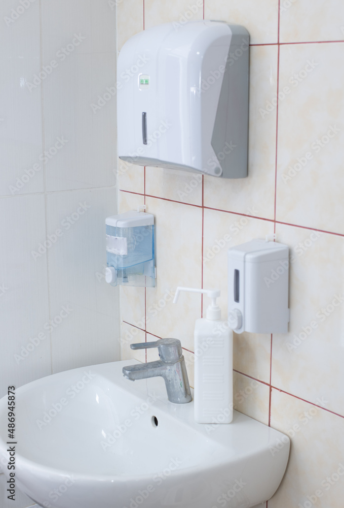 Fototapeta premium white sink with soap dispenser and antiseptic. concept is the necessary hygiene measures during a pandemic. Laboratory equipment