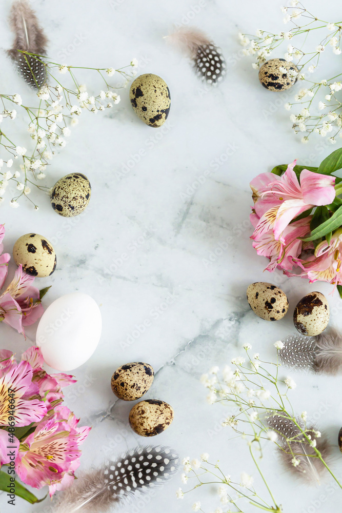 Happy easter! greeting card with quail eggs with feathers and spring pink flowers on white marble background. copy space, text, vertical Happy easter! greeting card with quail eggs with feathers and spring pink flowers on white marble background. copy space, text, vertical