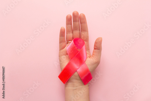 pink ribbon symbol of breast cancer on the palm