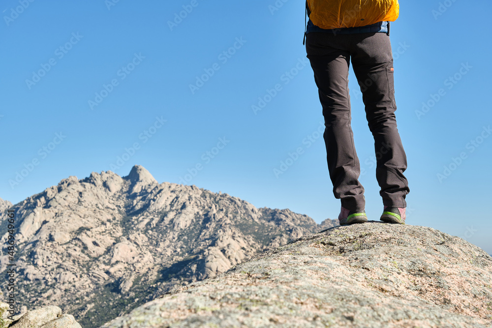 Hiker with a backpack standing on top of a rock and admire the mountains Hiker with a backpack standing on top of a rock and admire the mountains