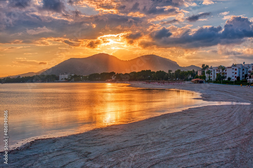 Beach of Alcudia town in sunset time photo