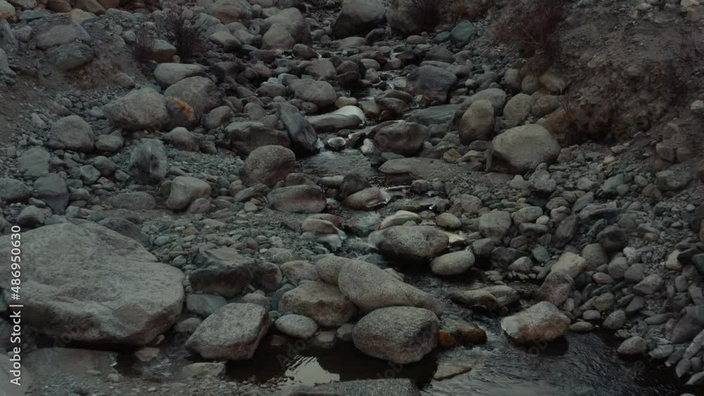 Close aerial shot of river water flowing through rocks in the mountains Close aerial shot of river water flowing through rocks in the mountains