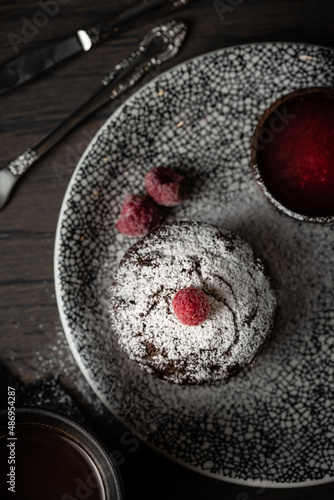 Plate of delicious fresh fondant with hot chocolate and blueberries on table. Lava cake recipe. High quality photo