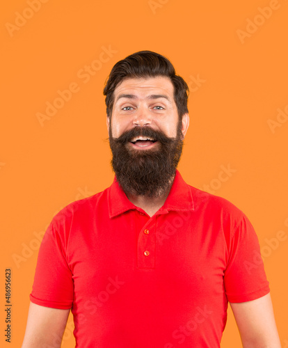 confident and handsome bearded man on orange background. hair and beard care.