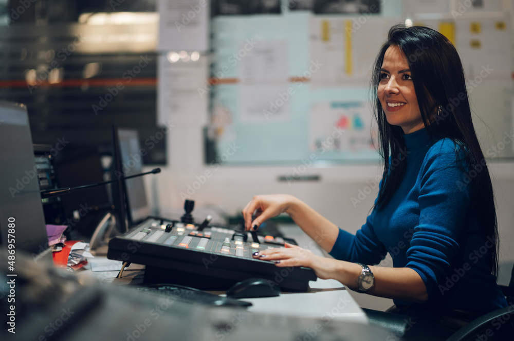 Middle aged woman using equipment in control room on a tv station Middle aged woman using equipment in control room on a tv station