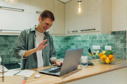 Redhead man using a laptop and having a video conference call at home © Zamrznuti tonovi