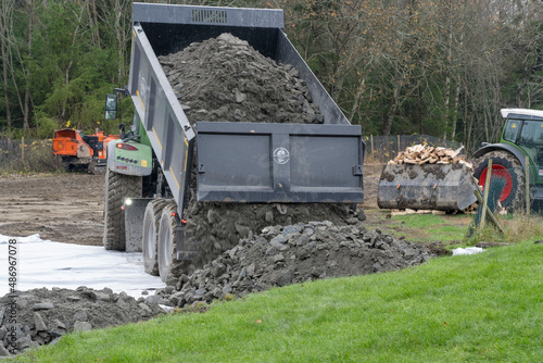 Emptying trailer with stones on the ground.