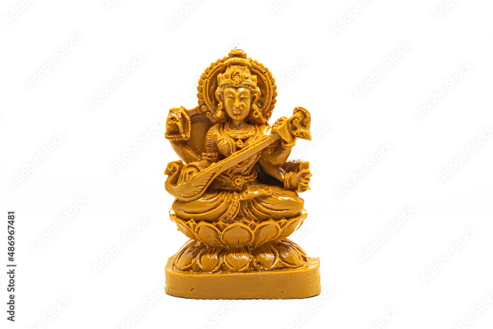 The statue of Saraswati carved in brown wood is isolated in white