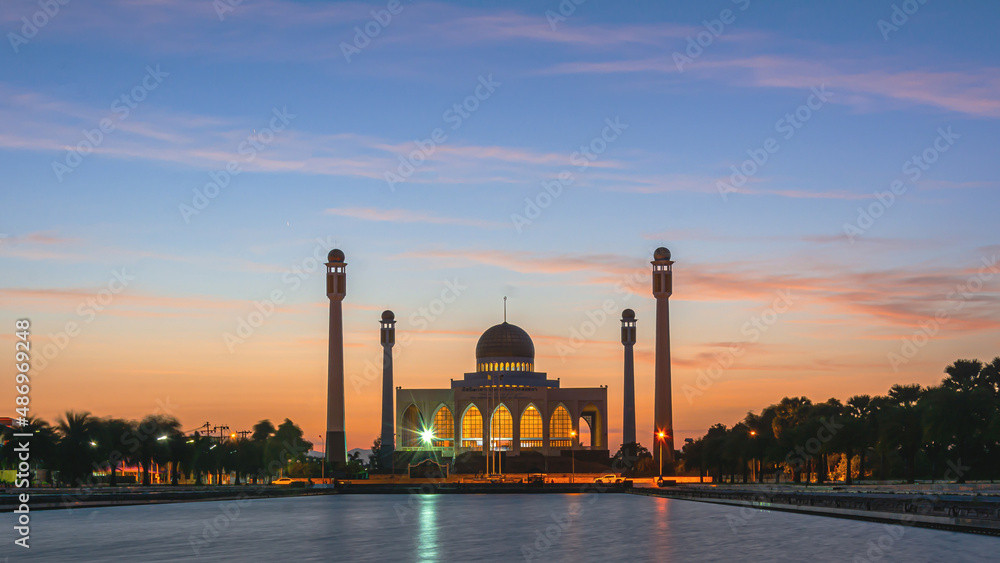 Songkhla Central Mosque in day to night with colorful skies at sunset and the lights of the mosque and reflections in the water in landmark landscape concept