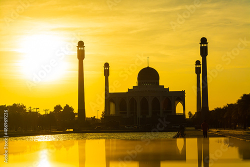 Songkhla Central Mosque in day to night with colorful skies at sunset and the lights of the mosque and reflections in the water in landmark landscape concept