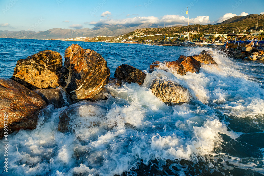 Rocks on the Coast Of Cretan Sea near Hersonissos, Crete, Greece. Aegean Sea with wawes and clouds.