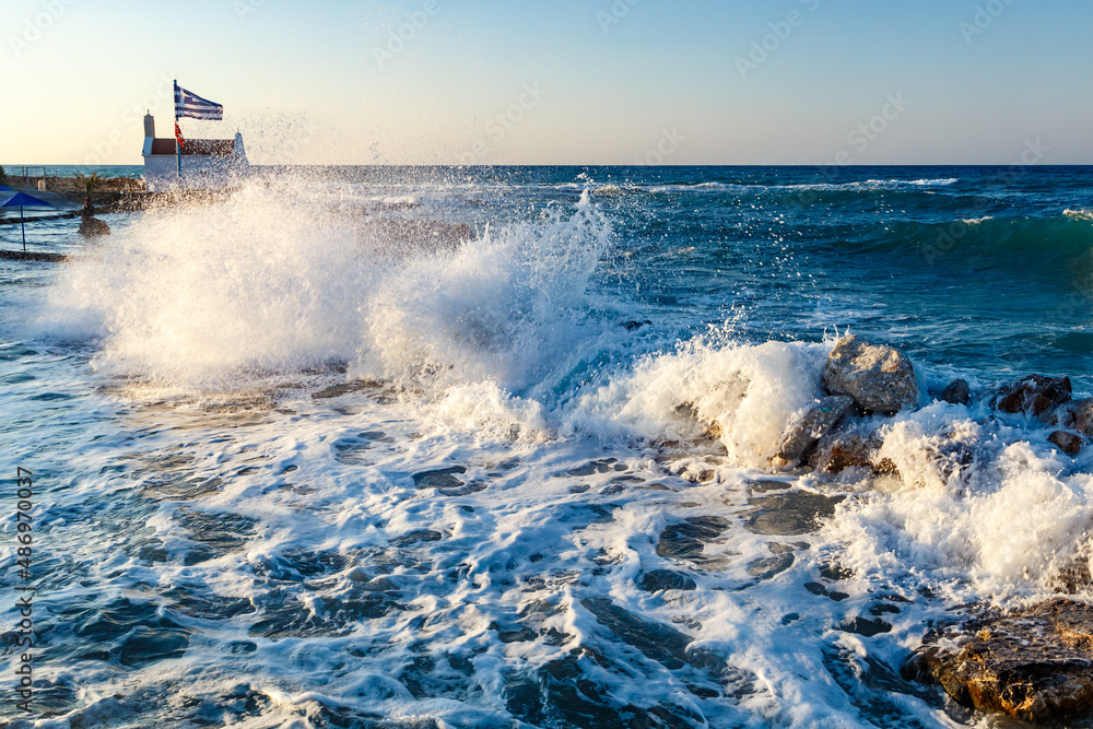 Beautiful Sea Landscape with Waves Breaking on a Sandy and Rocky Beach. Waves on Background. Summer time in Rhodes, Greece. rocks on the coast of blue sea on a sunny summer day