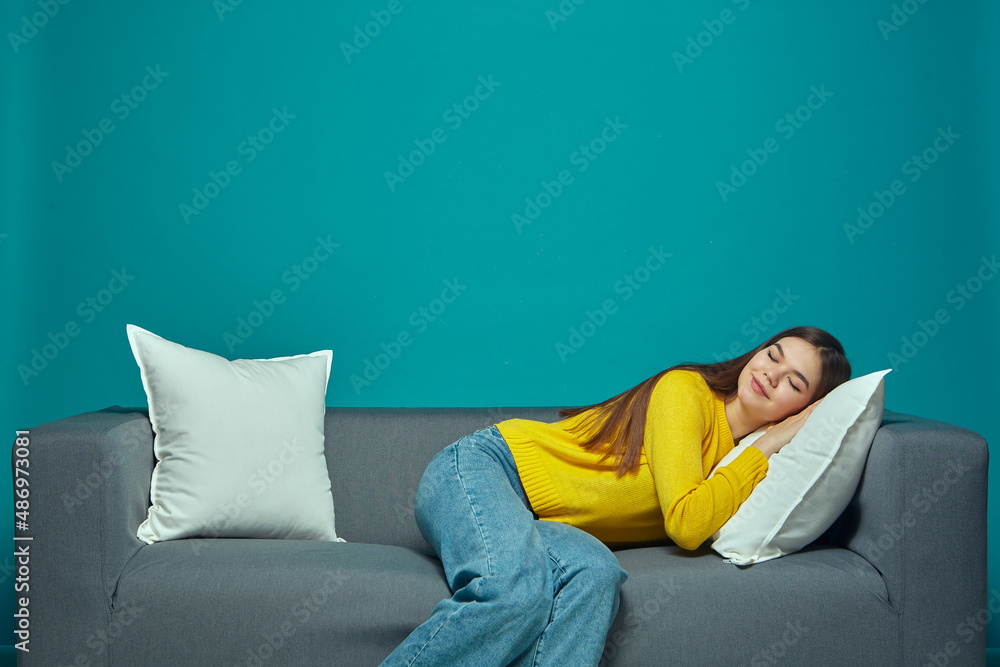 Pleased young girl enjoy break, relaxing during work day, lying on comfortable sofa. Healthy lifestyle, recreation Pleased young girl enjoy break, relaxing during work day, lying on comfortable sofa. Healthy lifestyle, recreation