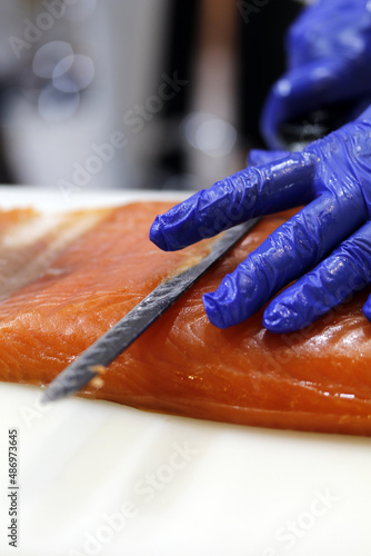profesional cortando lonchas de salmón ahumado photo