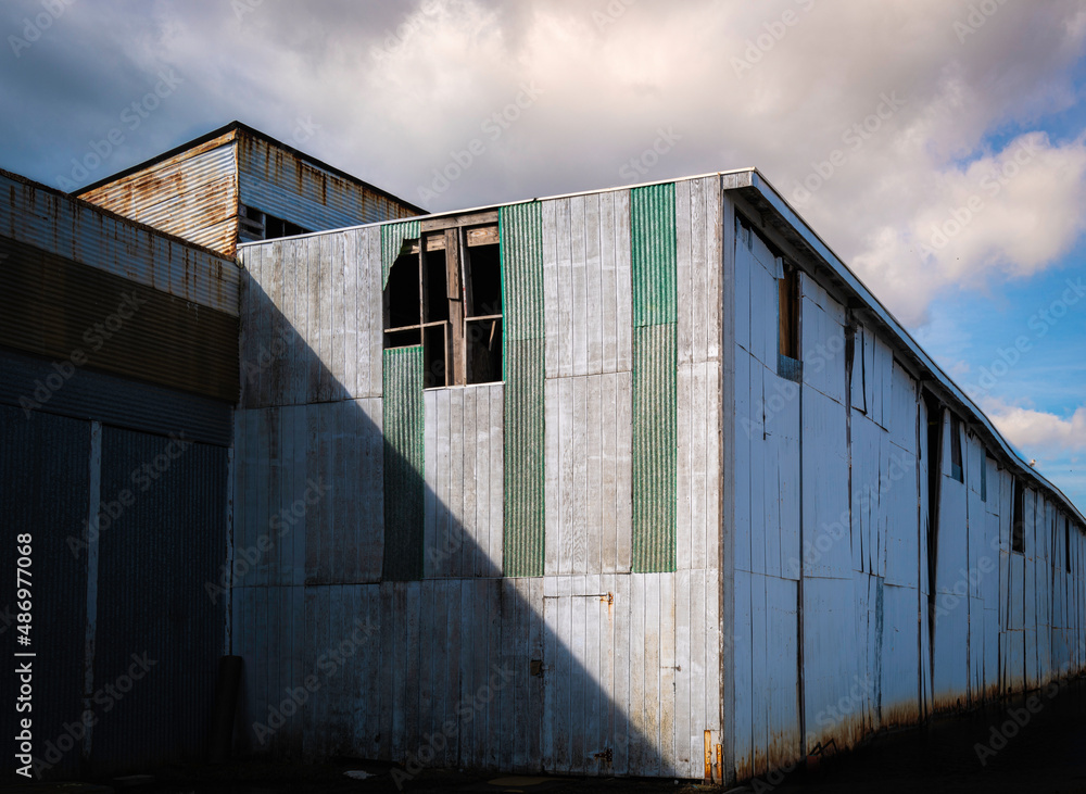 Abandoned rustic metal building warehouse. Abstract geometry of the shapes, lines, shadows, and light. Abandoned rustic metal building warehouse. Abstract geometry of the shapes, lines, shadows, and light.