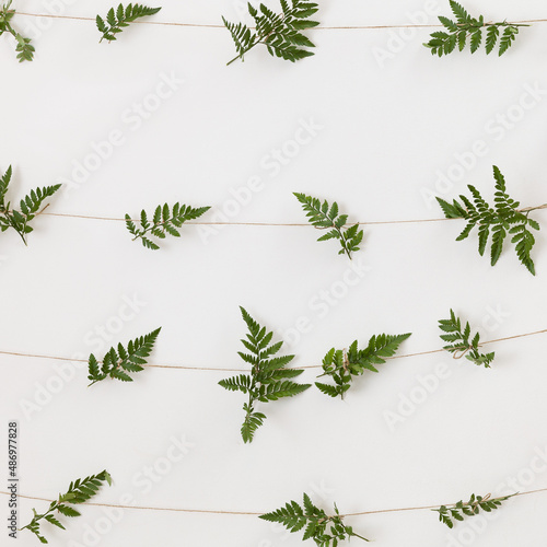 The wall is decorated with fern branches hanging on ropes. Holiday decor