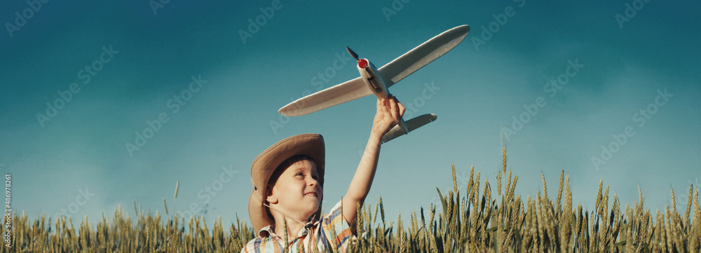 Happy kid playing with toy plane outside - success concept