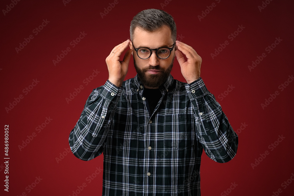 Portrait of a cool man with a beard, holding glasses with two hands Portrait of a cool man with a beard, holding glasses with two hands