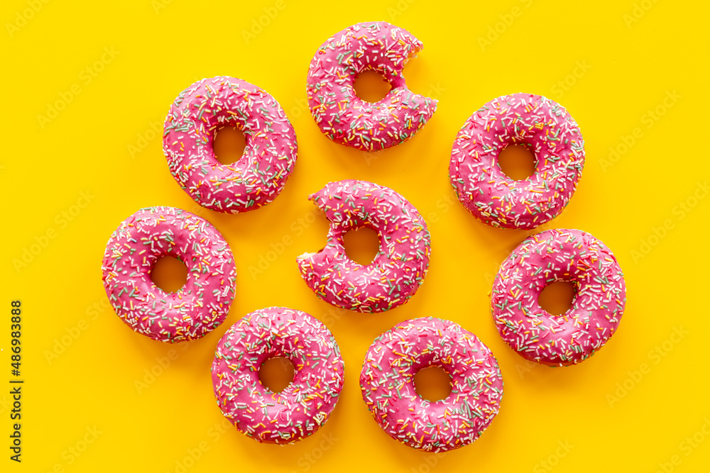 Pink frosted donuts with colorful sprinkles. Bakery background