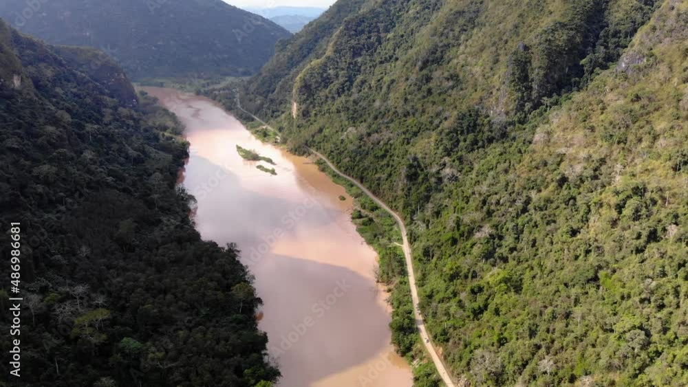 Aerial view of Nam Ou river leading to the remote village of Nong Khiaw in the Luang Prabang Province of northern Laos. Drone fly in wild nature jungle valley, mother earth unexplored unpolluted Aerial view of Nam Ou river leading to the remote village of Nong Khiaw in the Luang Prabang Province of northern Laos. Drone fly in wild nature jungle valley, mother earth unexplored unpolluted