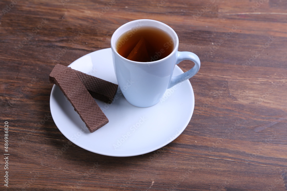 Chocolate Wafer on Wooden Plate, Served with Tea, Copy Space Chocolate Wafer on Wooden Plate, Served with Tea, Copy Space