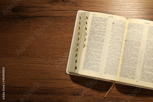 Canvastavla Open Bible on wooden table, top view. Space for text
