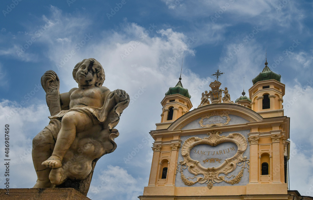 High-section of the Sanctuary of Madonna of the Coast (1630), protector of the seafarers, erected on the highest point of Sanremo, with a cherub statue in the foreground, Imperia, Liguria, Italy High-section of the Sanctuary of Madonna of the Coast (1630), protector of the seafarers, erected on the highest point of Sanremo, with a cherub statue in the foreground, Imperia, Liguria, Italy