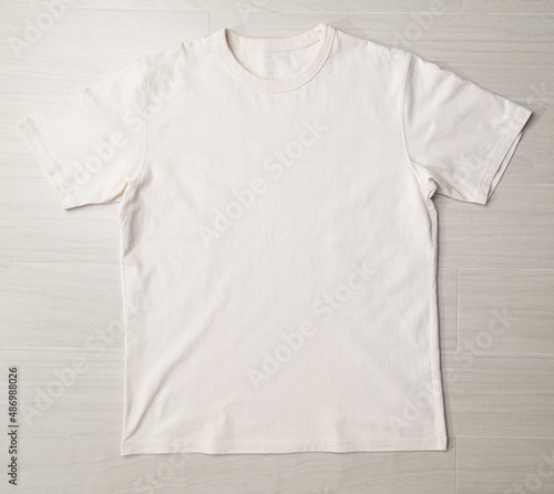 Blank beige T-shirt mockup template on the floor. © Touchr