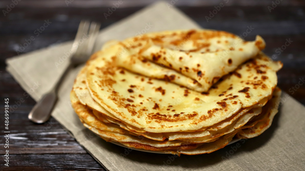 Selective focus. A stack of pancakes on a platter.