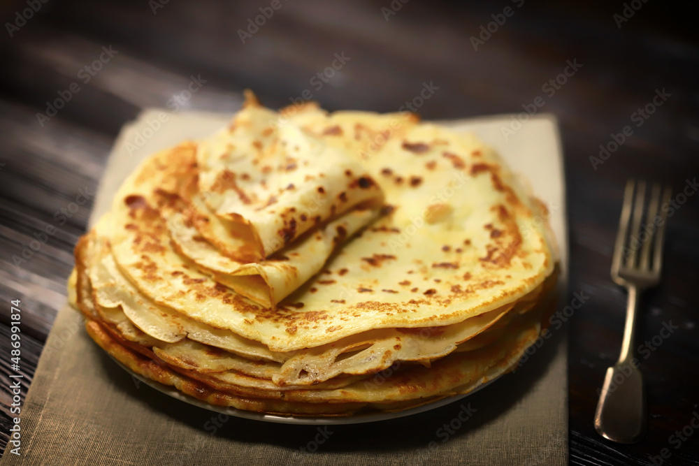 Selective focus. A stack of pancakes on a platter.