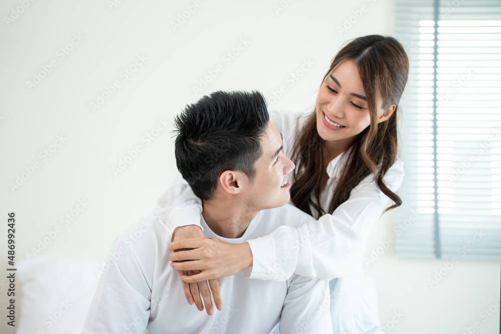 Portrait of Asian young couple sitting on bed and look at each other. Portrait of Asian young couple sitting on bed and look at each other.