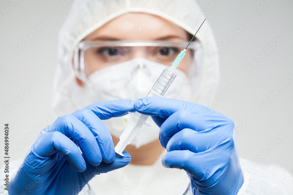 Female scientist holding vaccine syringe with needle Female scientist holding vaccine syringe with needle