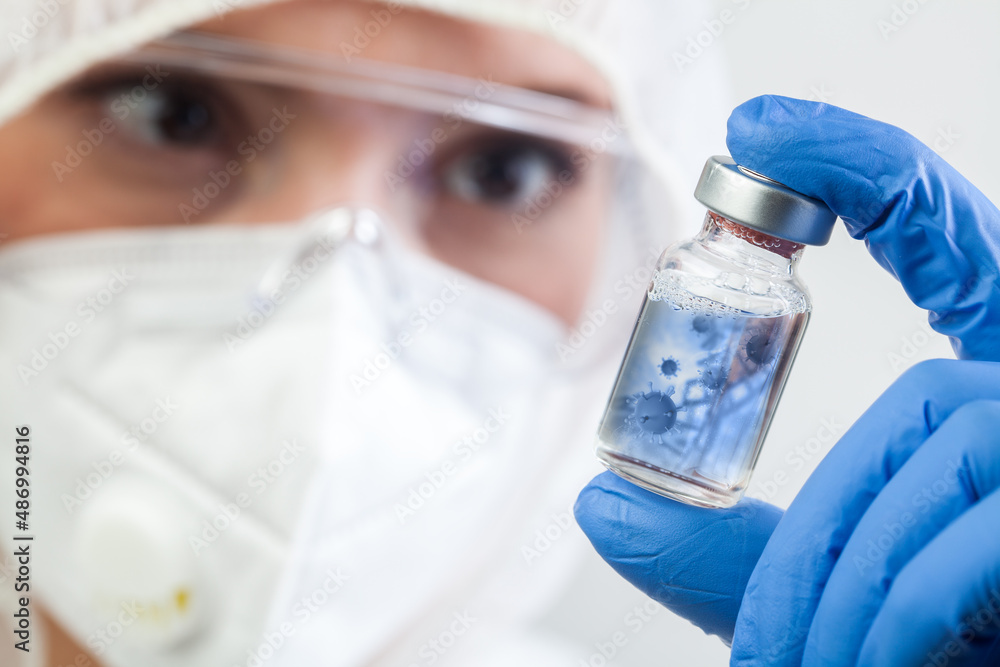 Female doctor or lab scientist holding glass ampoule vial with Coronavirus Female doctor or lab scientist holding glass ampoule vial with Coronavirus