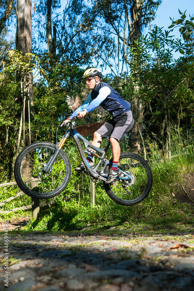 Obraz premium Mountain biker jumping on his bike on a trail in the woods
