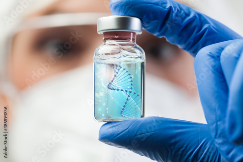 UK lab scientist biotechnologist holding glass ampoule vial with DNA strand