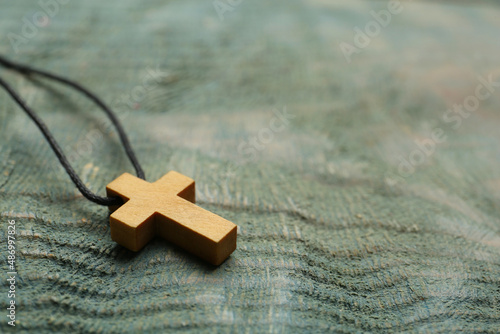 Valokuvatapetti Christian cross on wooden table, closeup. Space for text