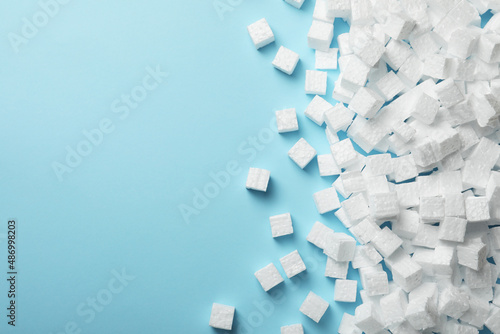Many styrofoam cubes on light blue background, flat lay. Space for text