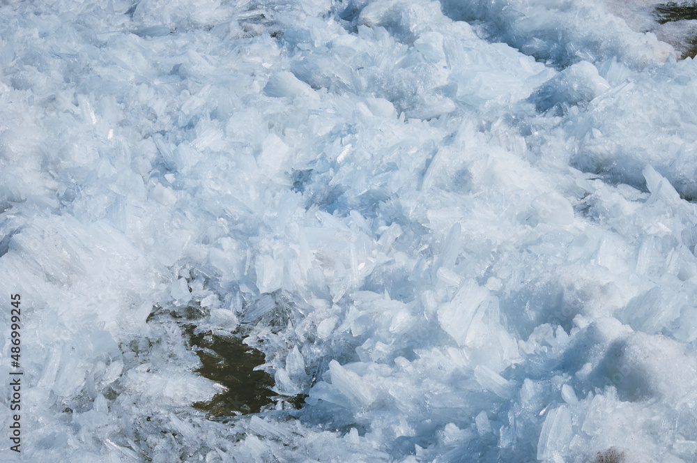 Fragments of ice with debris. River bank in spring. Loose texture. Breaks up into longitudinal crystals and melts under the bright rays of the sun. Fragments of ice with debris. River bank in spring. Loose texture. Breaks up into longitudinal crystals and melts under the bright rays of the sun.