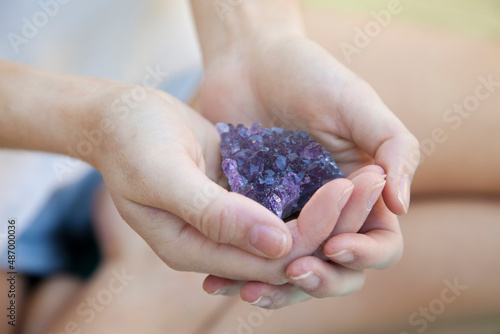 woman holding purple amethyst healing crystal