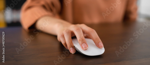 Close up of hand press the button computer mouse on table.