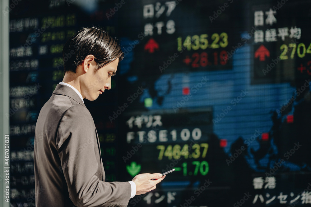 世界の市況をみる男性(株価ボード) 世界の市況をみる男性(株価ボード)