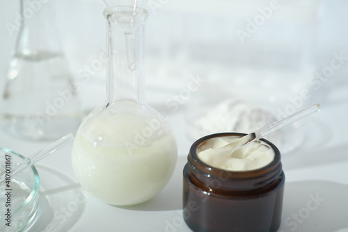 laboratory dishes and glassware on a lab table. fermentation, fermented beauty skin care. dropper bottle of solution or serum for anti age treatment.