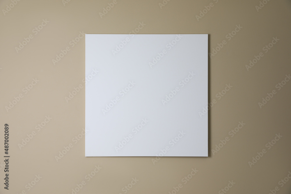 Blank canvas on beige wall. Space for design Blank canvas on beige wall. Space for design