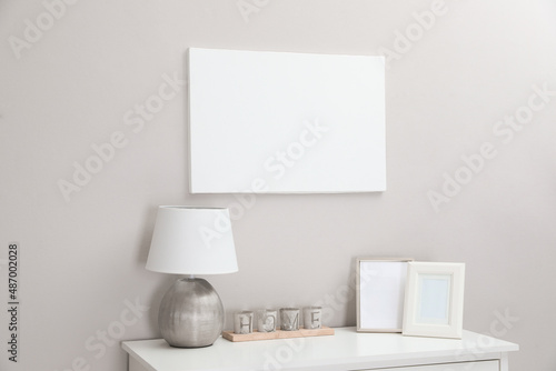 Blank canvas on wall over console table with decor indoors. Space for design © New Africa