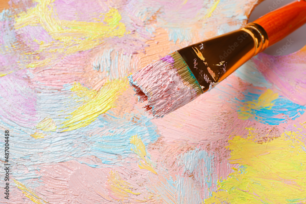 Obraz premium Closeup view of artist's palette with mixed pastel paints and brush as background