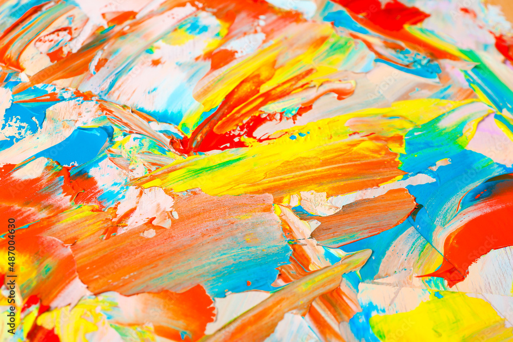Closeup view of artist's palette with mixed bright paints as background