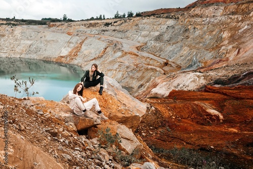 Girls in a post-apocalyptic place, a quarry with red earth and stones in work clothes