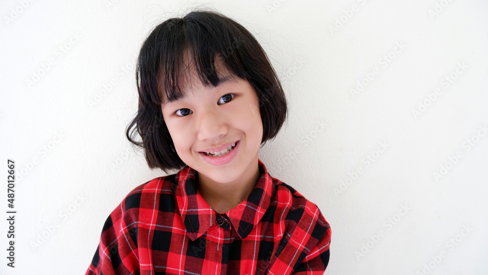 A picture of a half-bred girl wearing a red shirt smiling face against the backdrop of the wall A picture of a half-bred girl wearing a red shirt smiling face against the backdrop of the wall