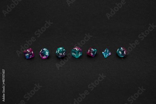 Blue and violet dices for fantasy dnd and rpg tabletop games. Board game polyhedral dices with different sides isolated on black background	
