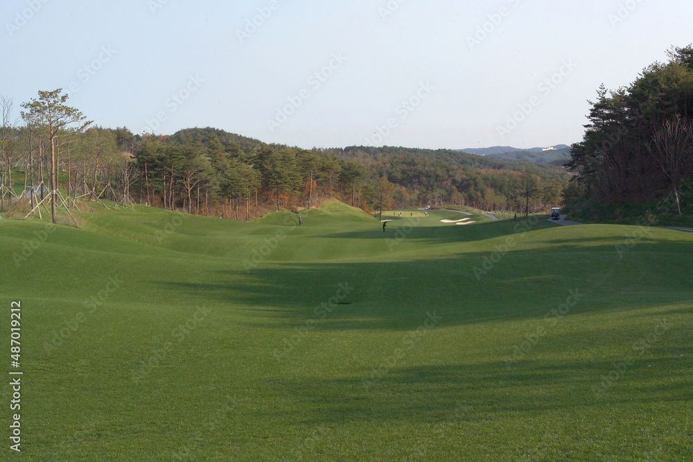 A view of the golf course with people playing golf A view of the golf course with people playing golf